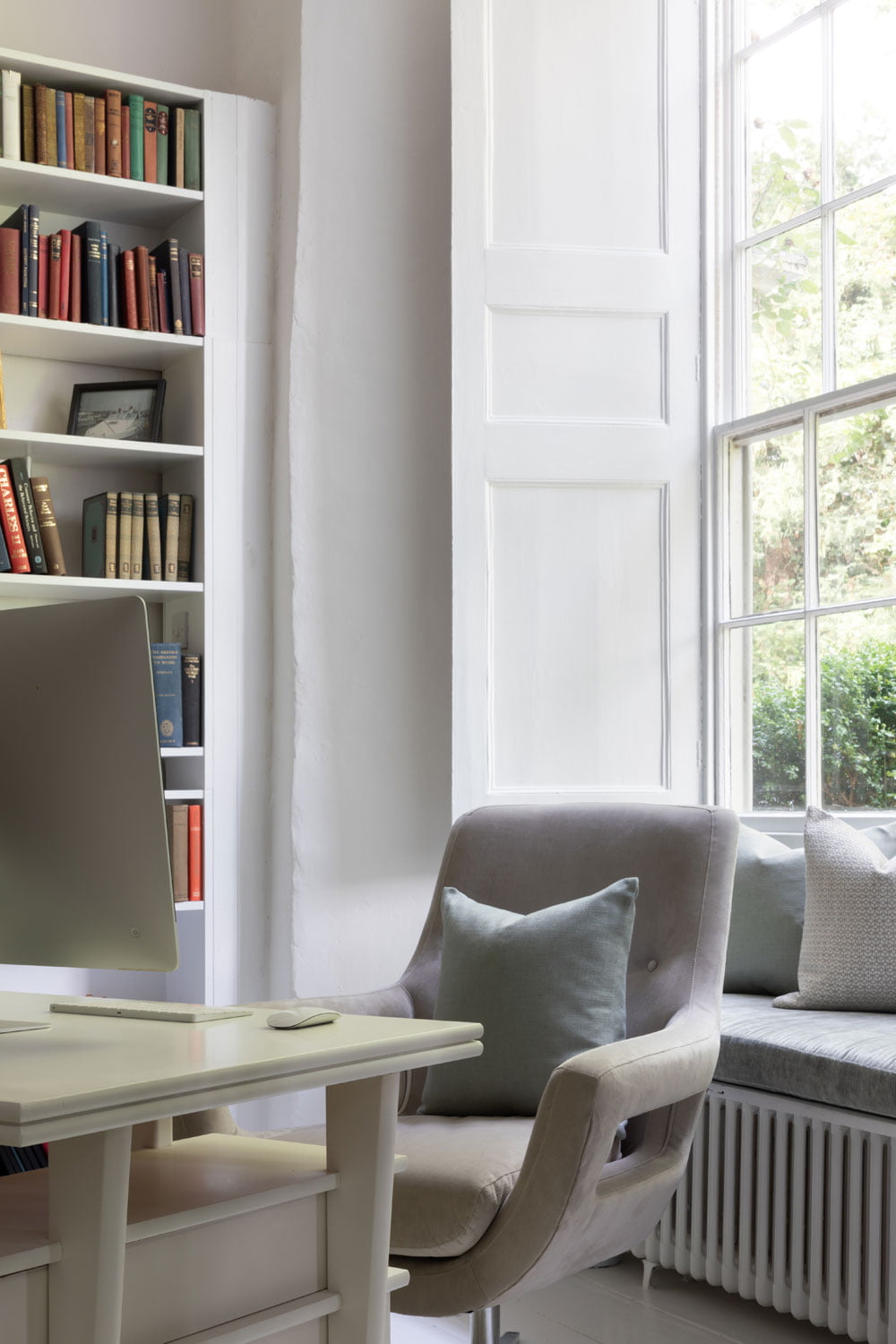White office room with book shelf and window with shutters