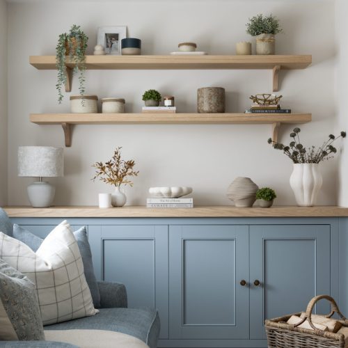 Bespoke joinery unit with blue cupboards and tiered shelving to wall above